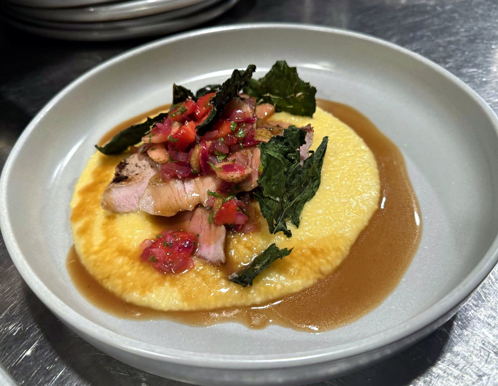 Grilled pork chop over polenta with kale chips and a strawberry relish